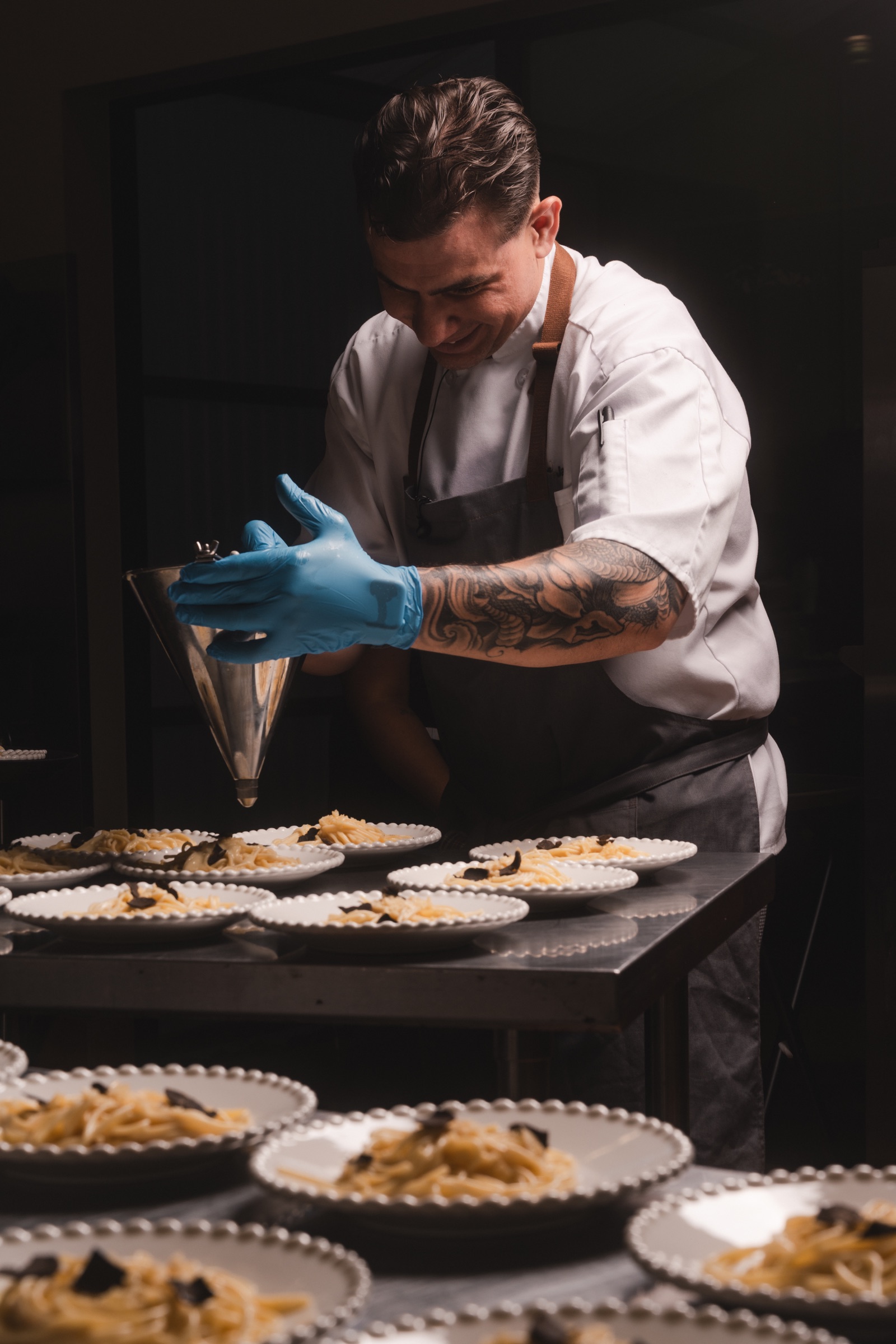 Chef plating a full run of dishes during service