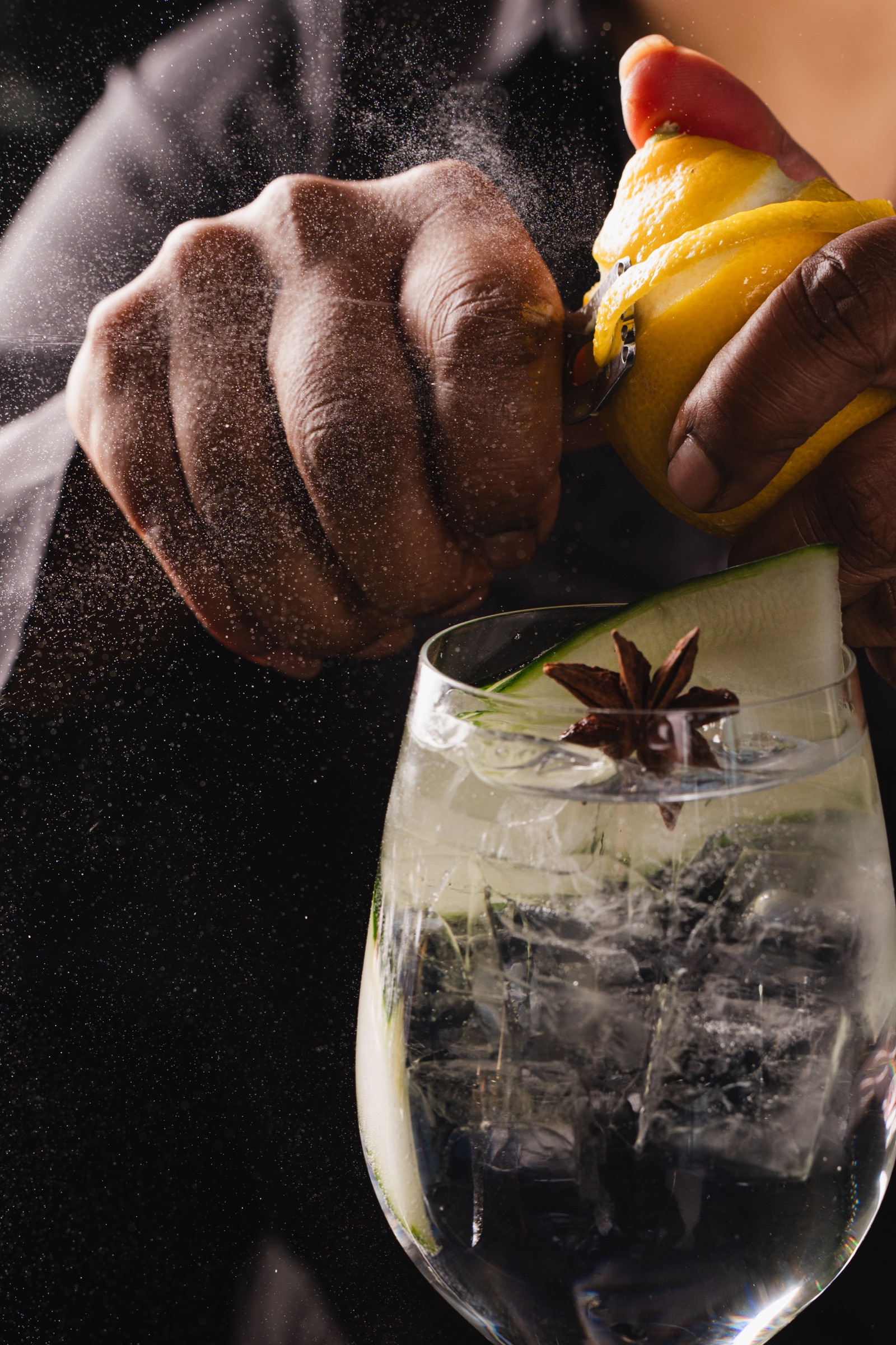 Bartender expressing citrus oils over a finished cocktail