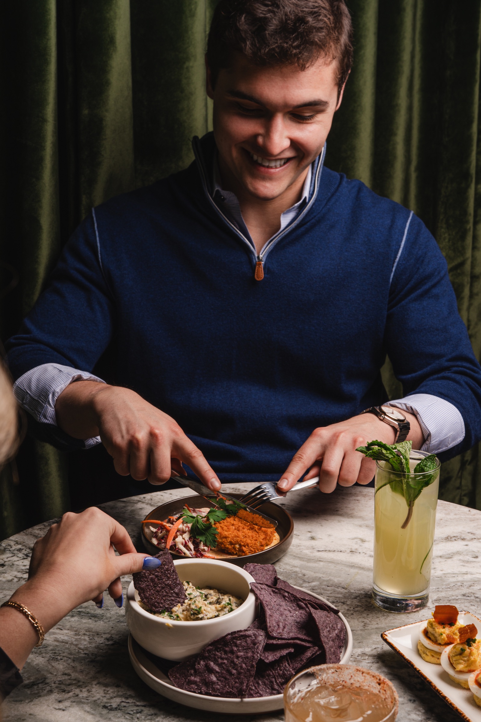 Guest enjoying a meal and cocktail at the table